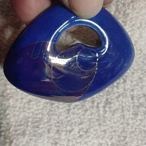 Large dark blue pendant looks like fired clay maybe? Initial s or g on back